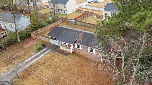 an aerial view of a house with a yard and trees