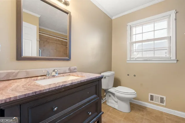 a bathroom with a granite countertop toilet sink and mirror