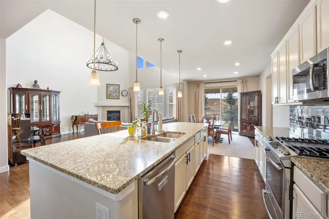 a kitchen with stainless steel appliances granite countertop a sink stove and refrigerator