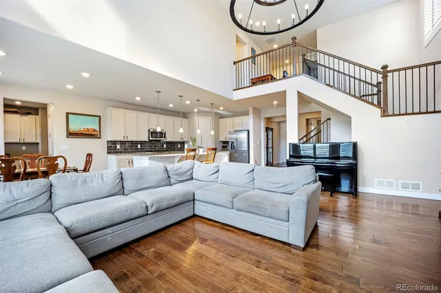 a living room with furniture kitchen view and a chandelier