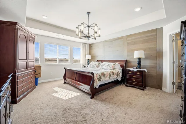 a bedroom with a bed and dresser with chair