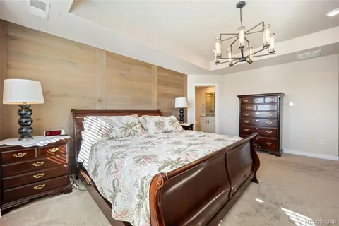 a bed sitting in a bedroom and chandelier