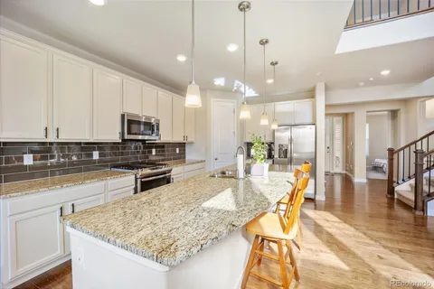 a kitchen with stainless steel appliances granite countertop wooden cabinets sink and stove