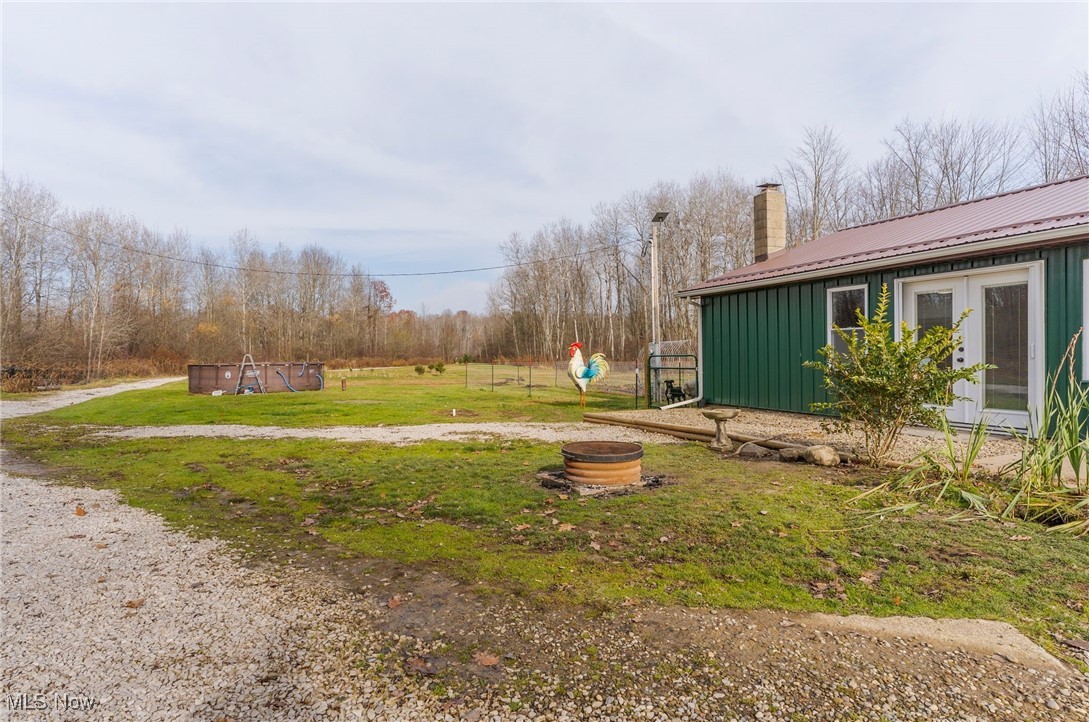 6590 Hall Road Andover, OH 44003 - Photo 19 of 29 View of green lawn featuring a fire pit and french doors