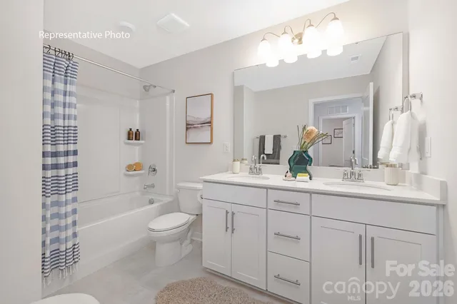 a bathroom with a double vanity sink toilet mirror and bathtub