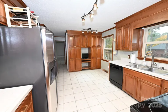 a kitchen with stainless steel appliances granite countertop a refrigerator a sink and dishwasher