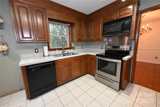 a kitchen with stainless steel appliances a refrigerator a sink a stove top oven and cabinets