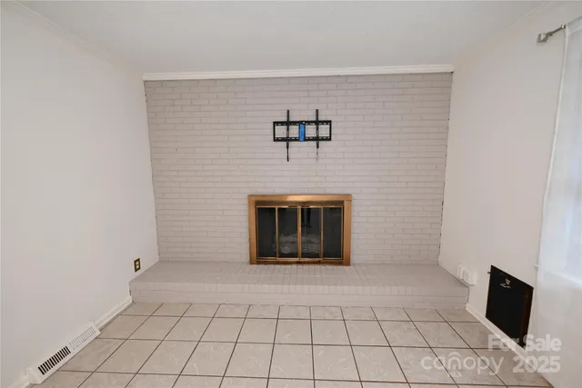 a view of an empty room with window and chandelier fan