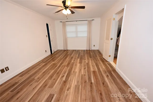 a view of a room with wooden floor staircase and a ceiling fan