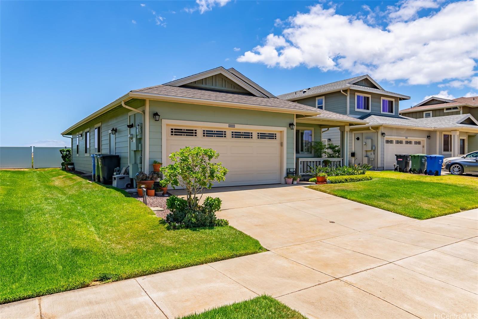 91-1129 Iliahialoe Loop Ewa Beach, HI 96706 - Photo 2 of 25 a front view of a house with a garden and plants