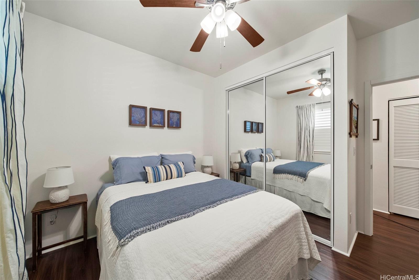 91-1129 Iliahialoe Loop Ewa Beach, HI 96706 - Photo 21 of 25 a bedroom with a bed and a chandelier