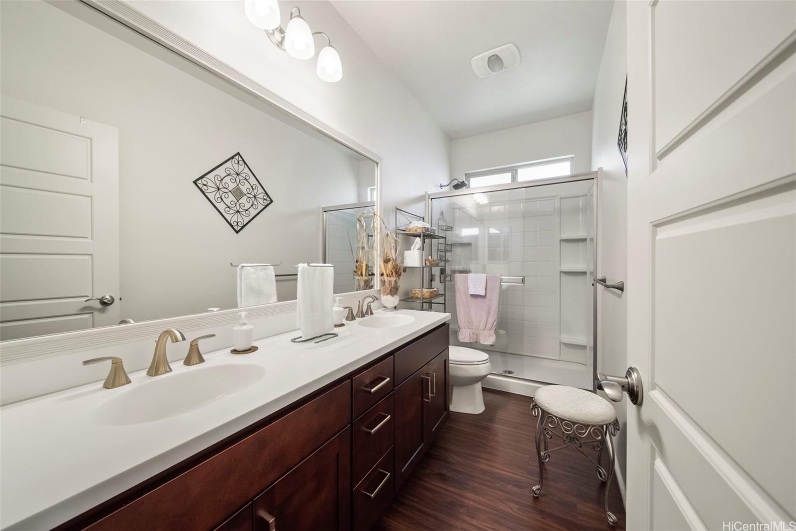 91-1129 Iliahialoe Loop Ewa Beach, HI 96706 - Photo 24 of 25 a bathroom with a double vanity sink a mirror and a shower