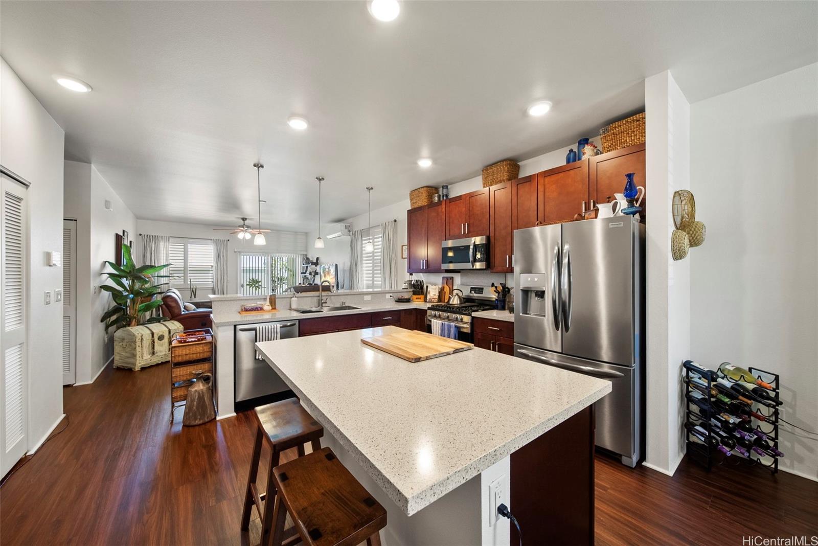 91-1129 Iliahialoe Loop Ewa Beach, HI 96706 - Photo 8 of 25 a kitchen with refrigerator a microwave and wooden floor
