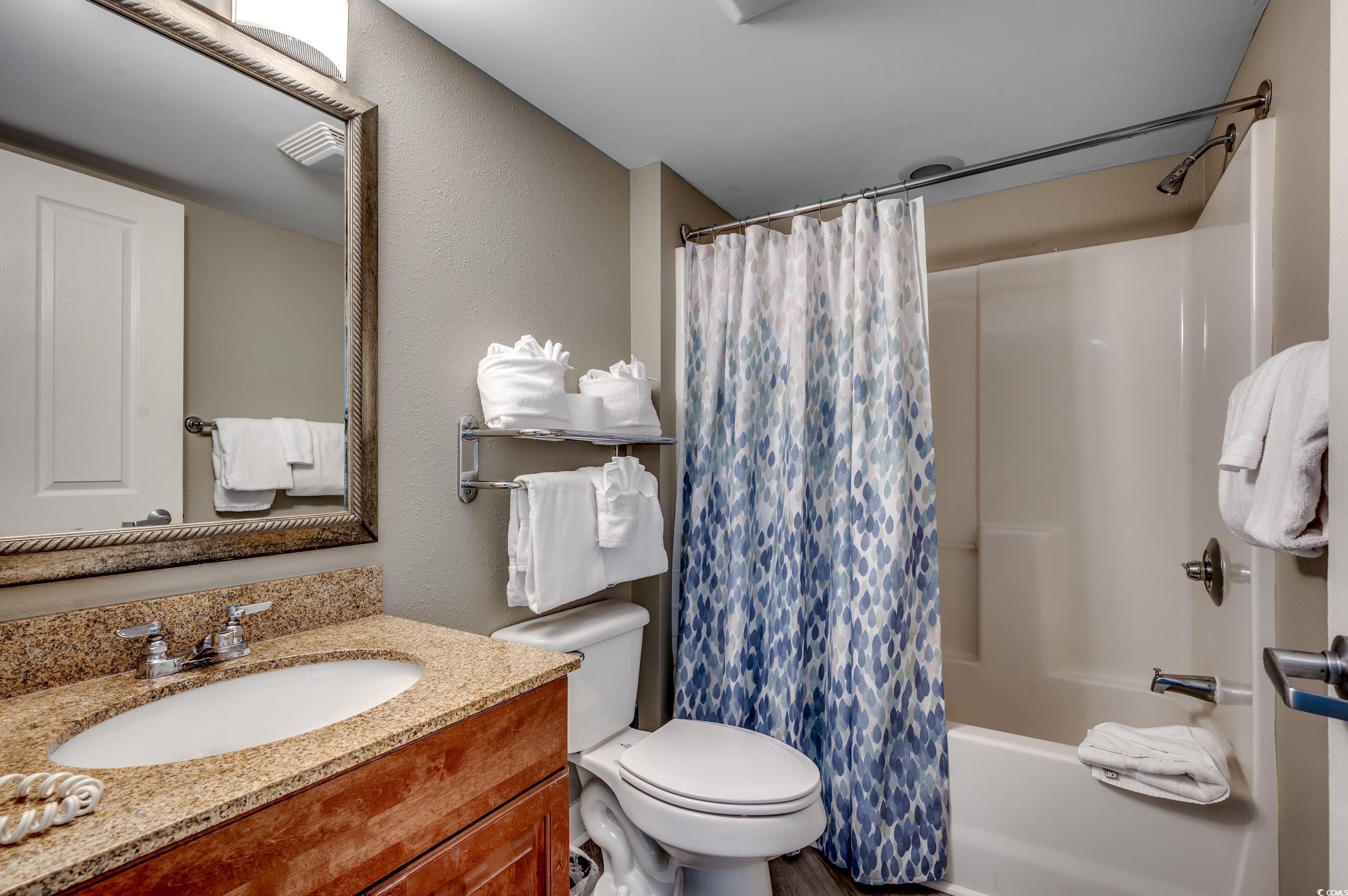 5200 North Ocean Boulevard, Unit 1037 Myrtle Beach, SC 29577 - Photo 17 of 40 Full bathroom with vanity, shower / bath combination with curtain, and a textured wall