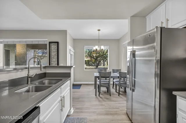 a kitchen with kitchen island a counter top space a sink stainless steel appliances and cabinets