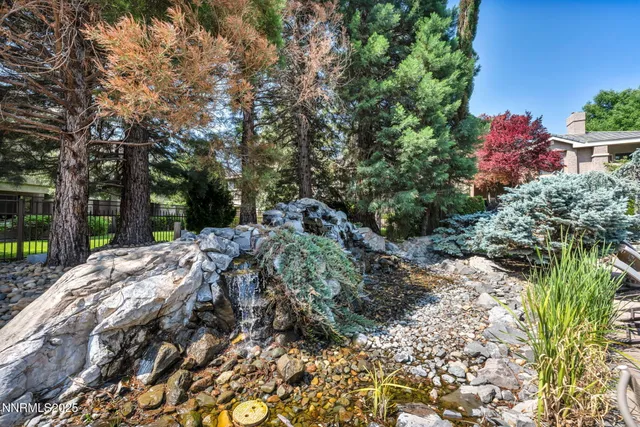 a living room with furniture a flat screen tv and floor to ceiling window