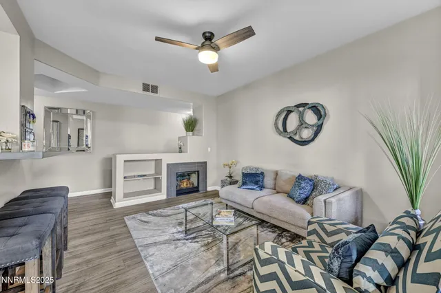 a living room with furniture a fireplace and wooden floor