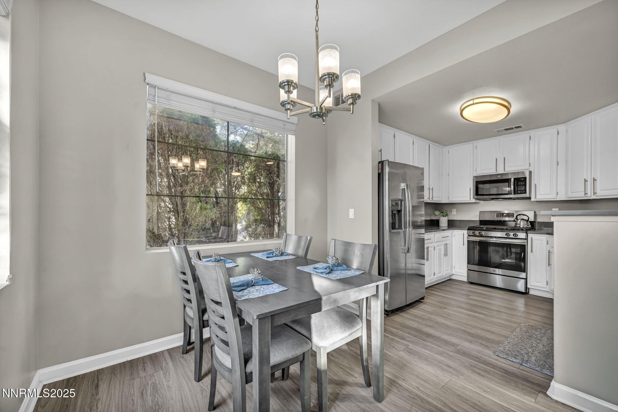 900 South Meadows Parkway, Unit 814 Reno, NV 89521 - Photo 8 of 43 a view of a dining room with furniture a chandelier and wooden floor