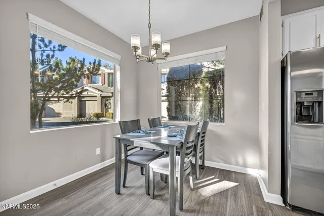 a view of a dining room with furniture a chandelier and wooden floor