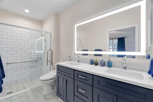 a bathroom with a double vanity sink toilet and shower