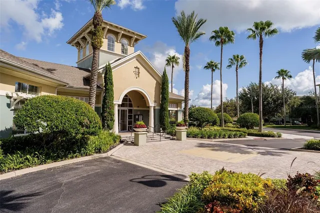 a front view of a house with a yard and palm trees