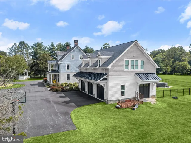 a view of a house with a big yard and large trees