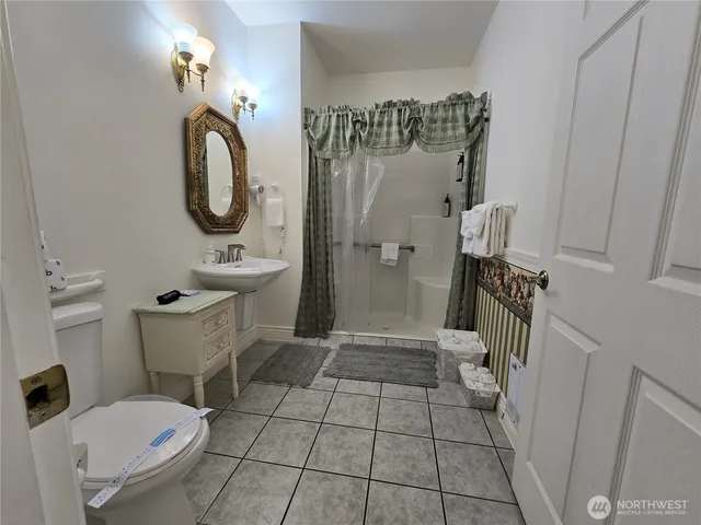 a bathroom with a toilet a sink and mirror