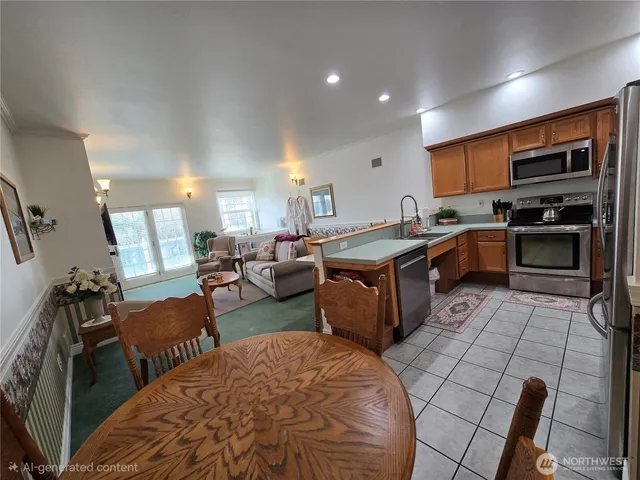 a kitchen with stainless steel appliances granite countertop a stove top oven a sink a dining table and chairs