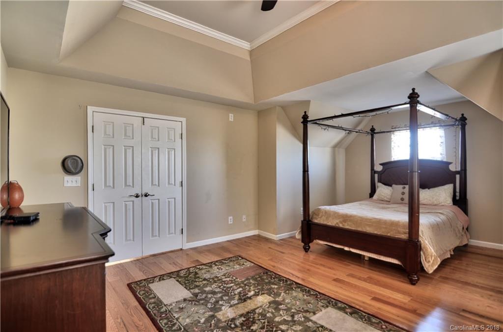 10435 Blackstock Road Huntersville, NC 28078 - Photo 21 of 33 a bedroom with a bed and wooden floor