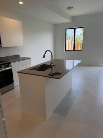 a kitchen with sink a stove and window
