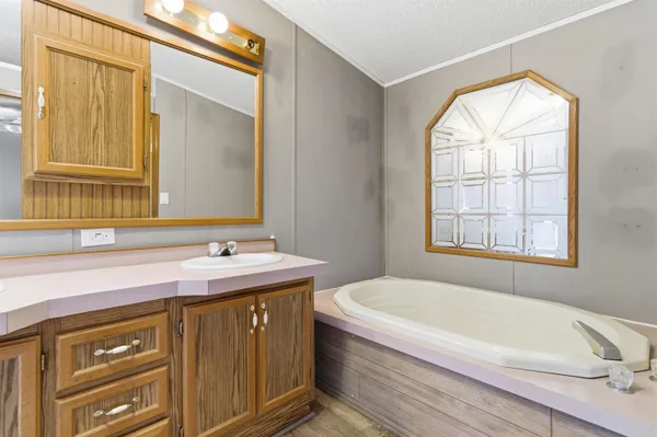 a bathroom with a tub sink and mirror