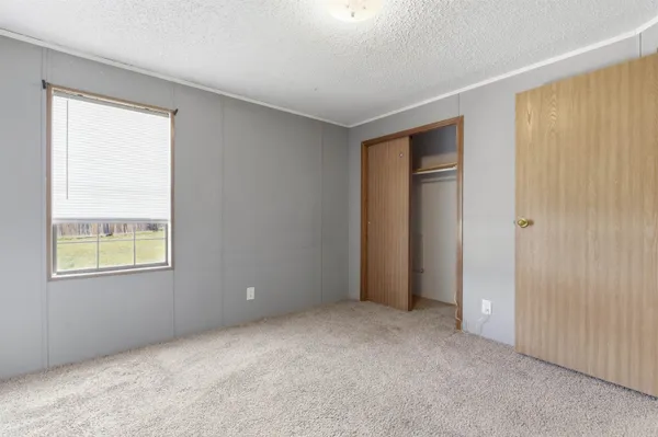 an empty room with windows and closet