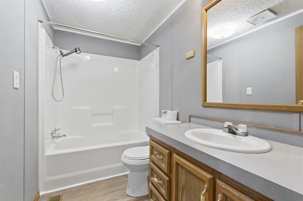 a bathroom with a granite countertop sink toilet and shower