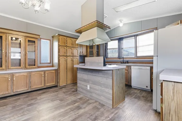 a kitchen with granite countertop a refrigerator and white cabinets