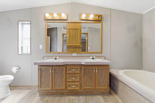a bathroom with a granite countertop toilet a sink and mirror