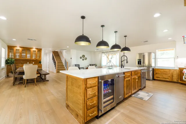 a kitchen with stainless steel appliances granite countertop a sink a stove and a wooden floors