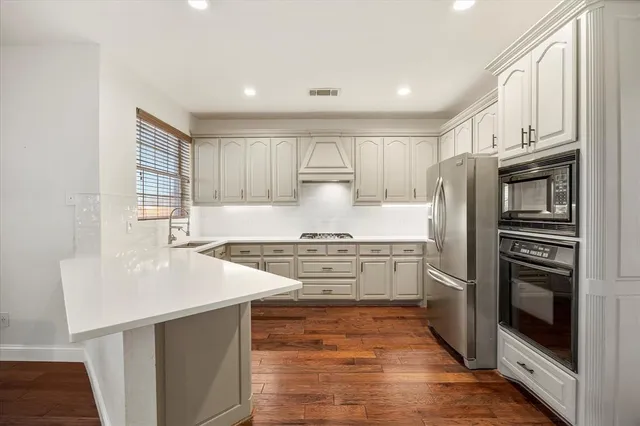 a kitchen with stainless steel appliances granite countertop a stove a sink and a refrigerator