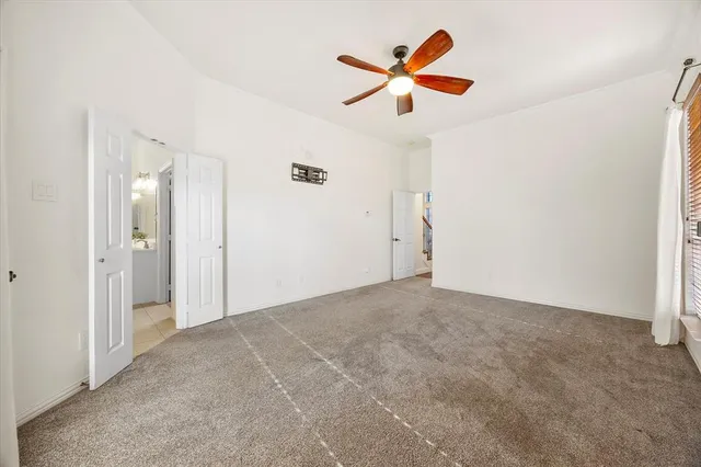 an empty room with closet and fan