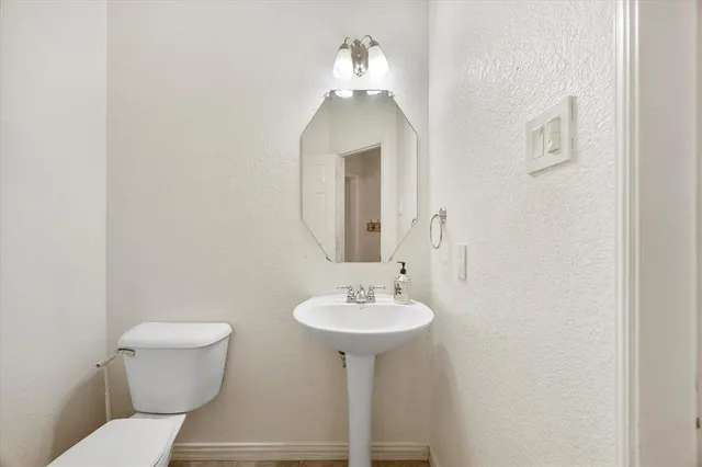 a bathroom with a sink toilet and a mirror
