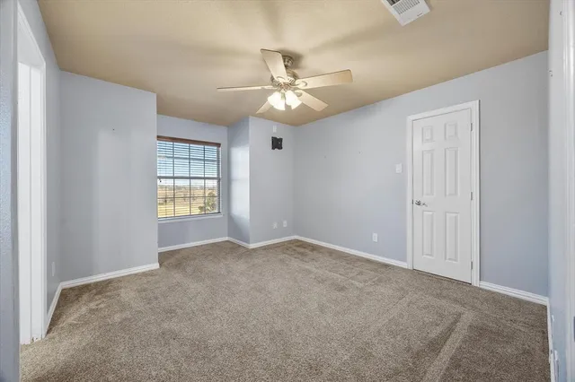 an empty room with closet and windows