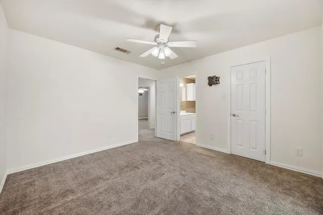 an empty room with a white cabinet and a ceiling fan