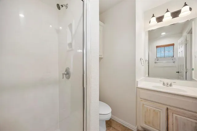 a bathroom with a sink a toilet a shower and a mirror