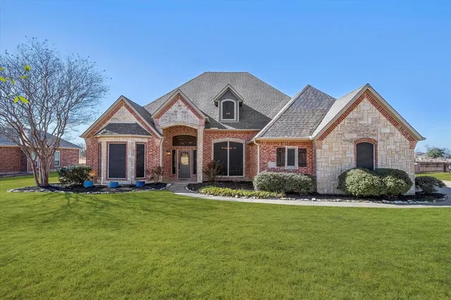 a front view of a house with a garden and trees