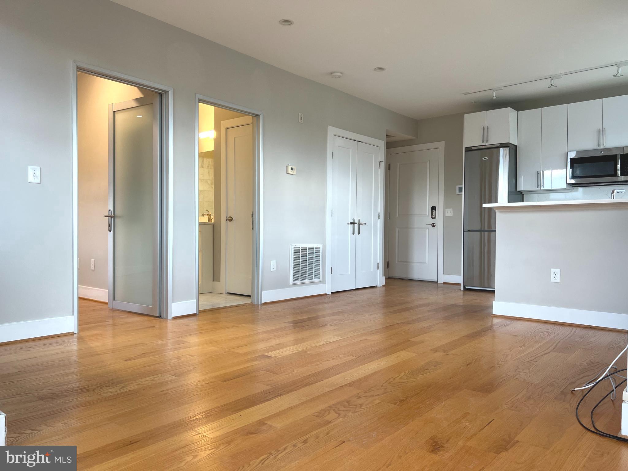 1209 G Street Southeast, Unit 8 Washington, DC 20003 - Photo 4 of 27 a view of empty room with wooden floor and kitchen