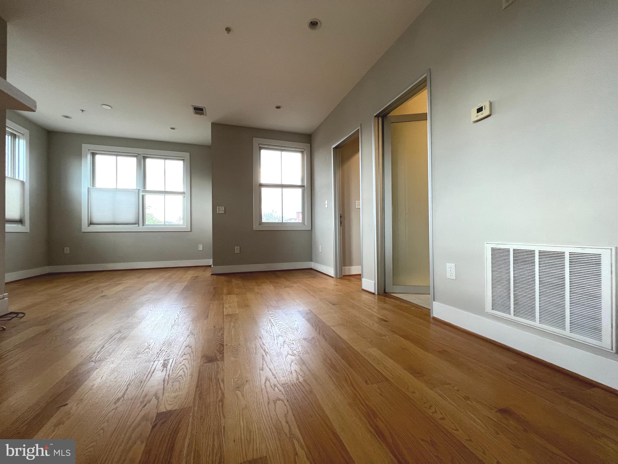 1209 G Street Southeast, Unit 8 Washington, DC 20003 - Photo 7 of 27 an empty room with wooden floor and windows