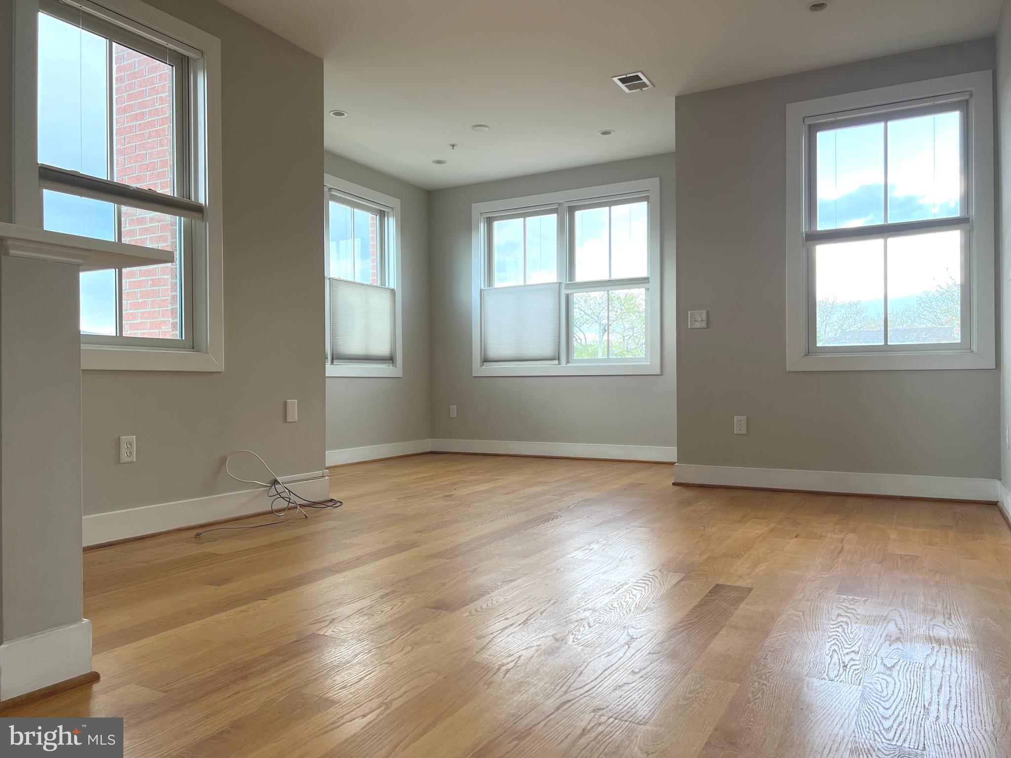 1209 G Street Southeast, Unit 8 Washington, DC 20003 - Photo 8 of 27 a view of an empty room with wooden floor and a window
