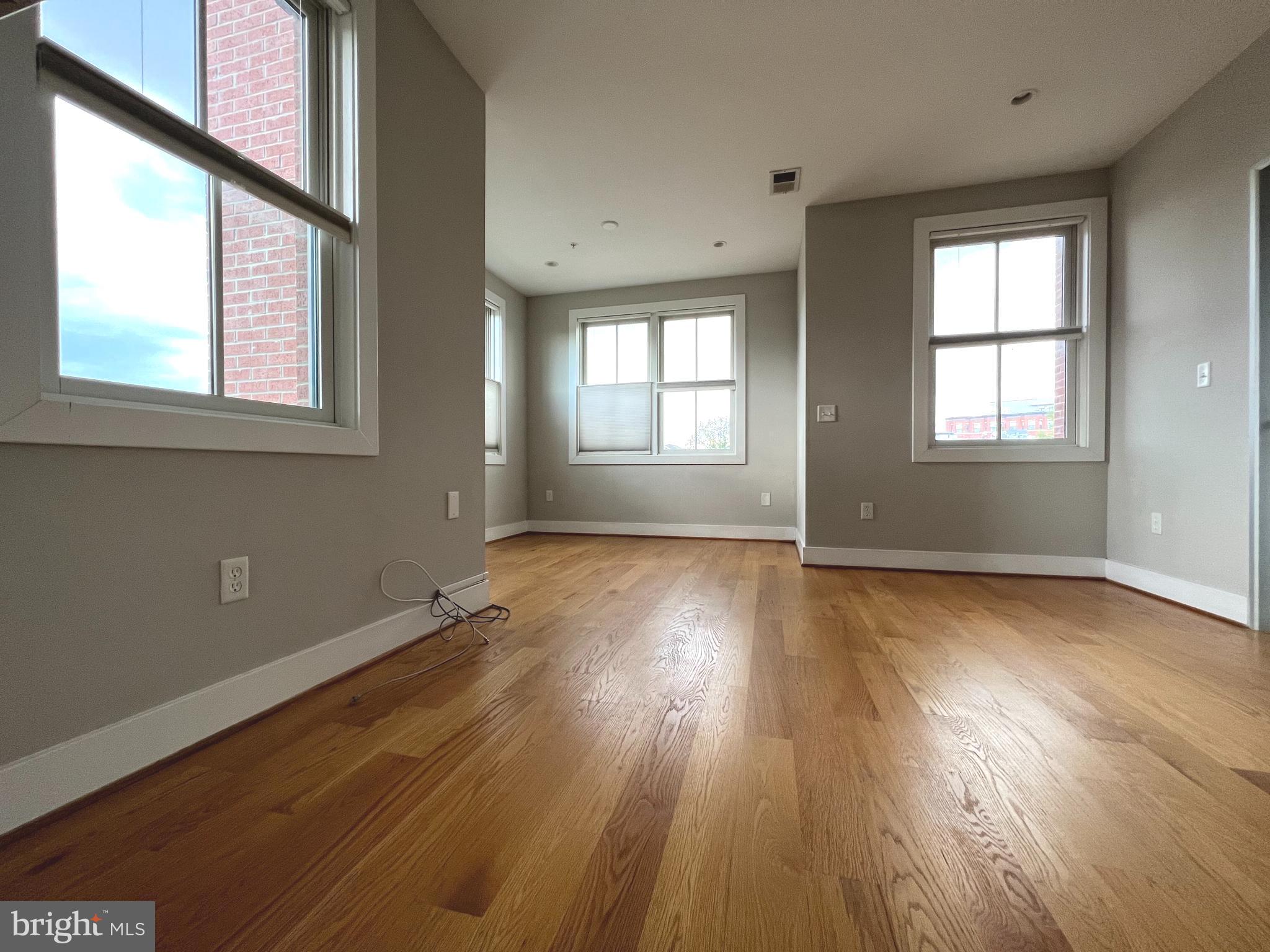 1209 G Street Southeast, Unit 8 Washington, DC 20003 - Photo 9 of 27 an empty room with wooden floor and windows