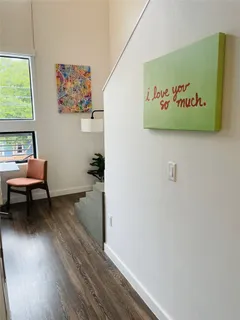 a view of a hallway with wooden floor and a workspace