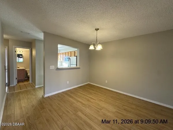 an empty room with wooden floor mirror and windows