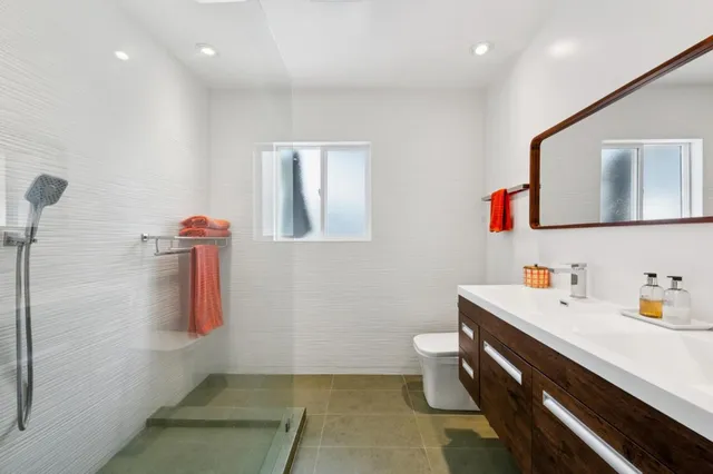 a bathroom with a toilet sink and mirror